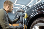 Odborník odstraňujúci preliačiny na karosérii automobilu pomocou PDR technológie bez poškodenia pôvodného laku.