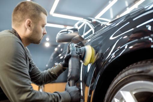 Odborník odstraňujúci preliačiny na karosérii automobilu pomocou PDR technológie bez poškodenia pôvodného laku.